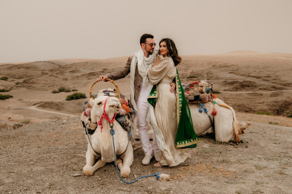 Bride and groom portraits with camel in the desert at Marrakech wedding venue